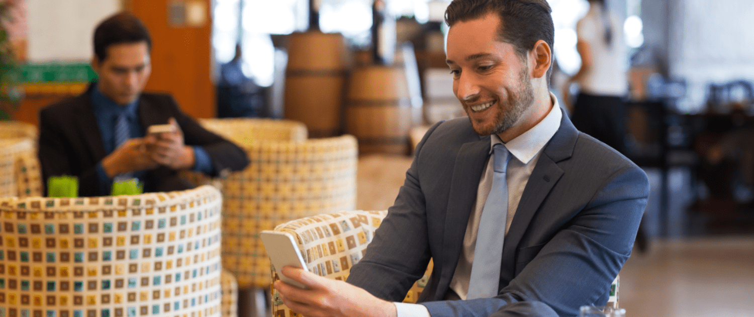 Image of a man using phone in a hotel. Depicts smart hotel automation.